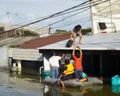Warga di Blok 8, Perumnas Antang, Kecamatan Manggala, memakai perahu karet menyusuri genangan banjir/Muh. Syawal - Bollo.id