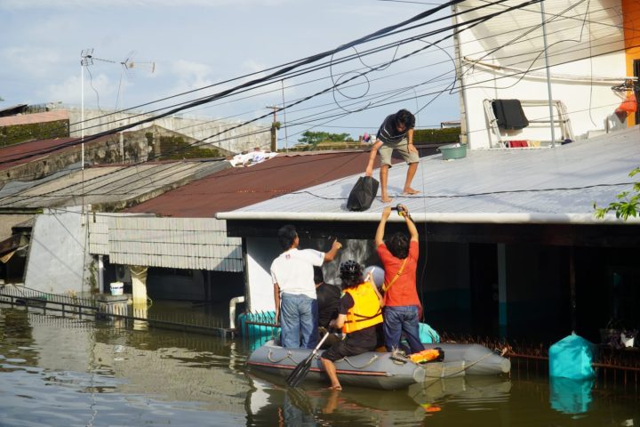 Warga di Blok 8, Perumnas Antang, Kecamatan Manggala, memakai perahu karet menyusuri genangan banjir/Muh. Syawal - Bollo.id