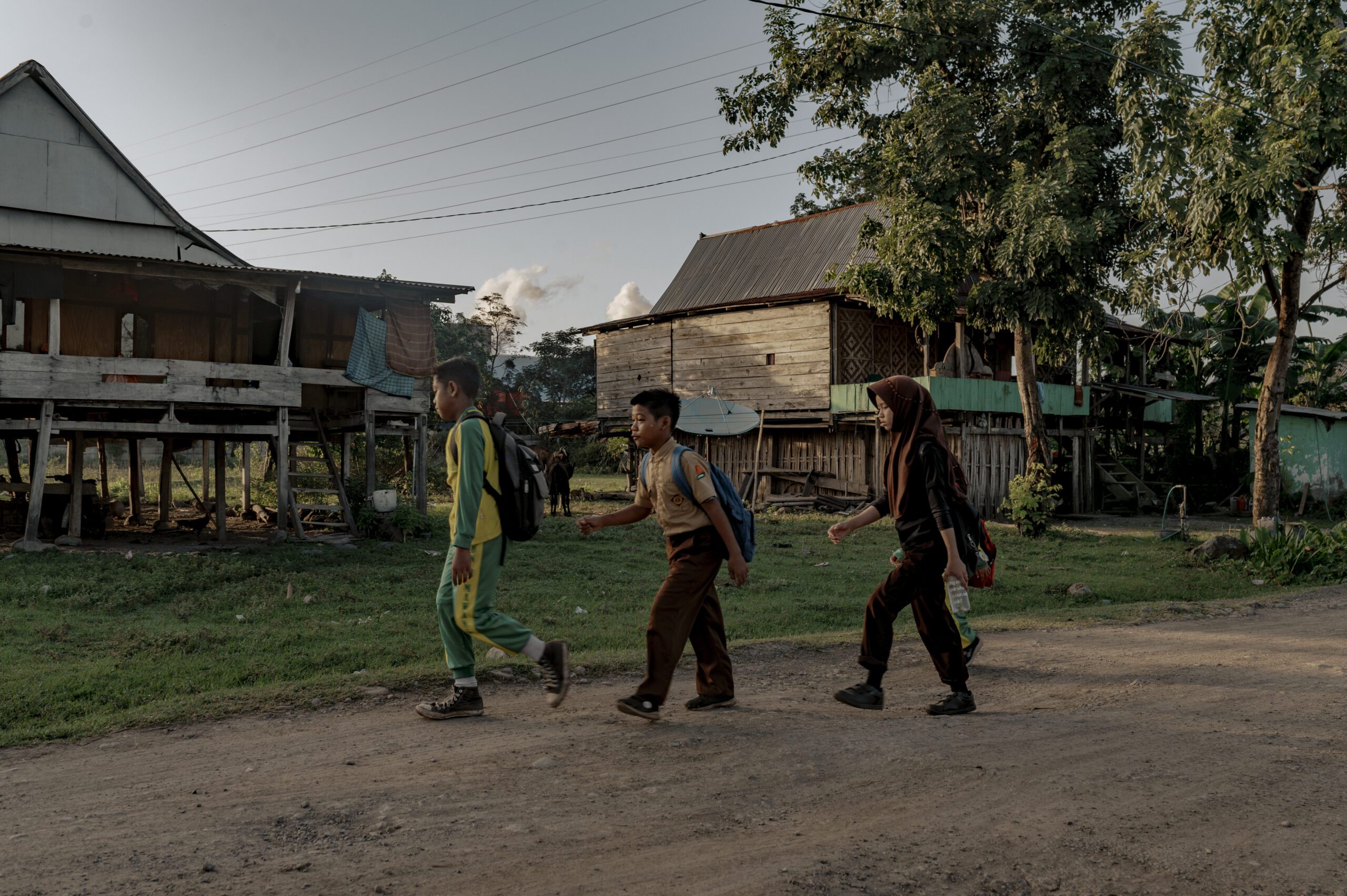 Siswa sekolah dasar berangkat ke sekolah yang tidak jauh dari industri smelter milik PT Huadi Group. Kelompok Anak-anak di Desa Papan Loe ini adalah kelompok yang paling rentan terkena penyakit akibat polusi udara aktivitas pengelolaan nikel/Iqbal Lubis untuk Bollo.id