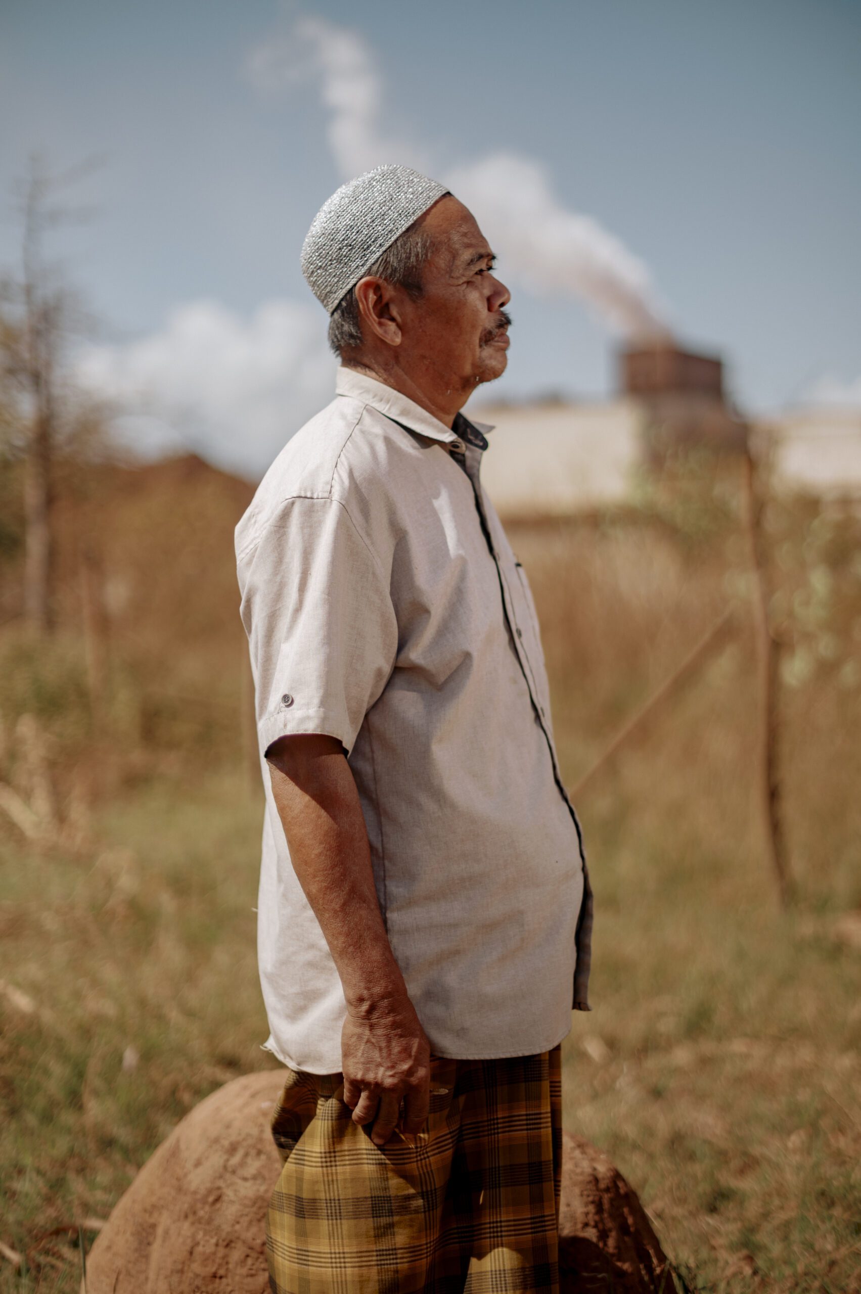 Haji Sampara Daeng Lili warga Desa Borong loe menatap ke arah industri smelter. Daeng Lili adalah satu dari sekian banyak petani yang lahan padinya rusak akibat limbah pabrik smelter, untuk pertama kalinya iya merasakan kerugian menanam padi di lahan miliknya sekitar 6 ha tidak ada yang bisa dipanen/Iqbal Lubis untuk Bollo.id