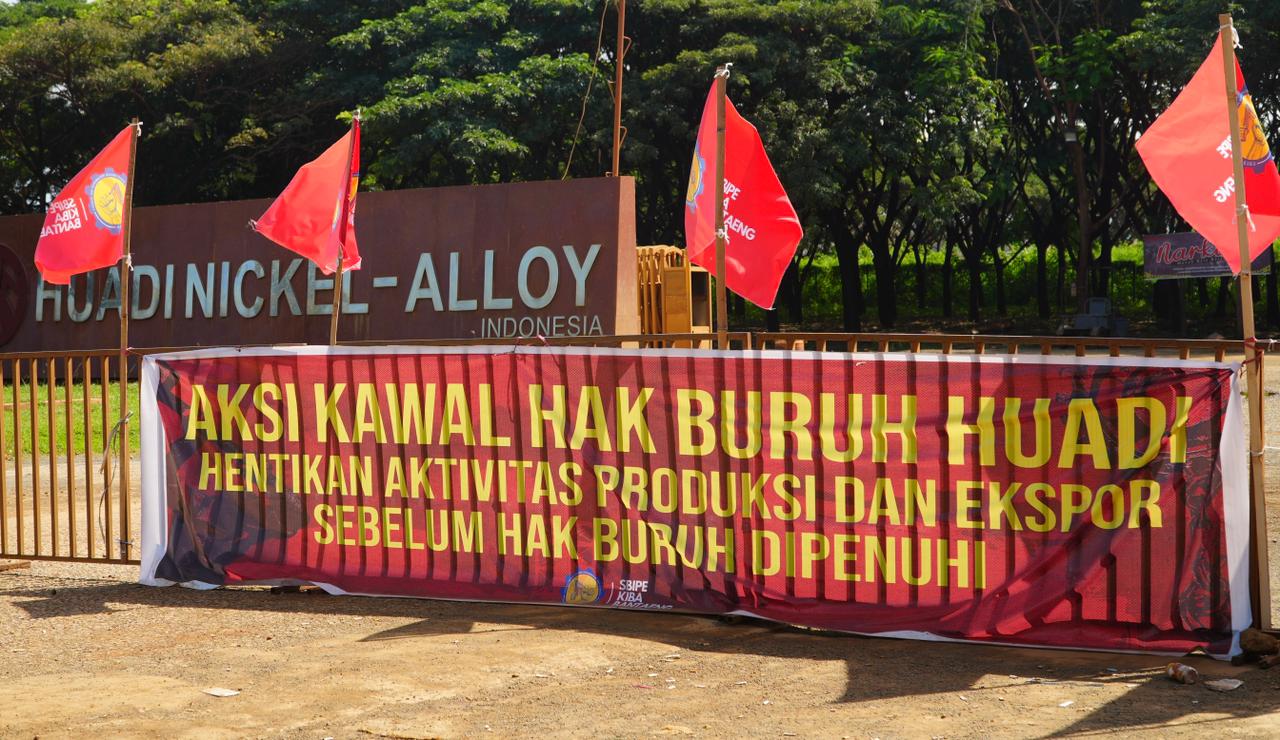 Spanduk protes buruh yang terpampang di pagar PT Huadi Nickel Alloy/Foto: Arya Nurprianugraha